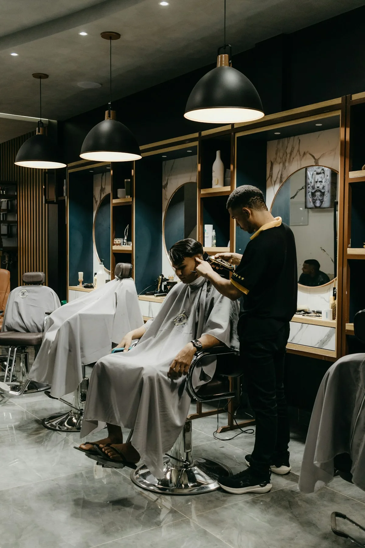 A barber cutting a client's hair in a barbershop
