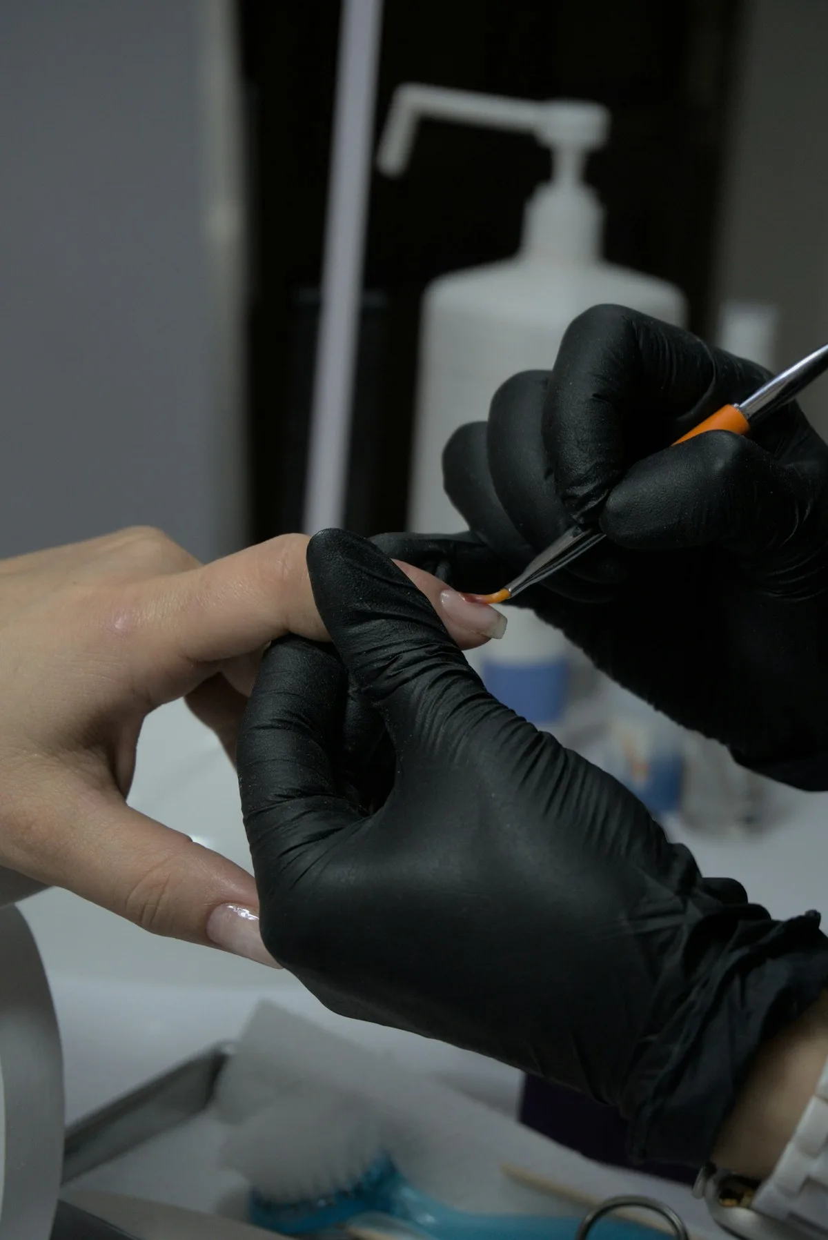 A nail technician taking care of a client's manicure booking